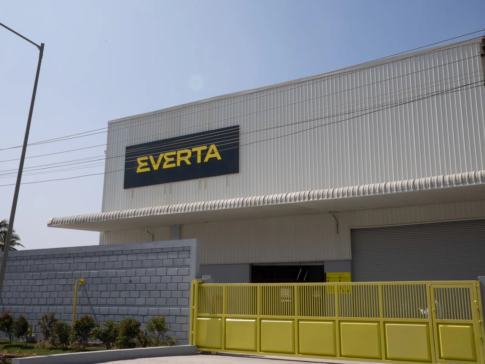 Everta factory exterior with signage and yellow gate — Everta